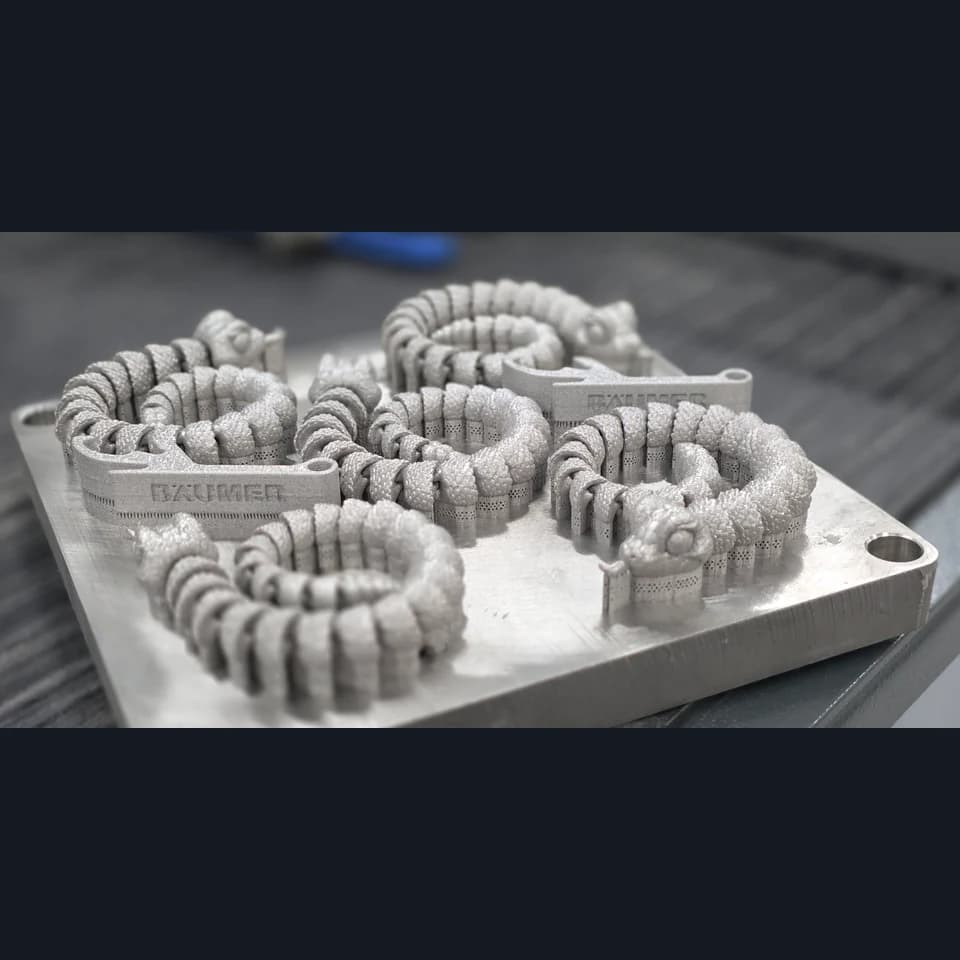 Five silver-coloured dragons with coiled bodies on a shared build plate with supports.