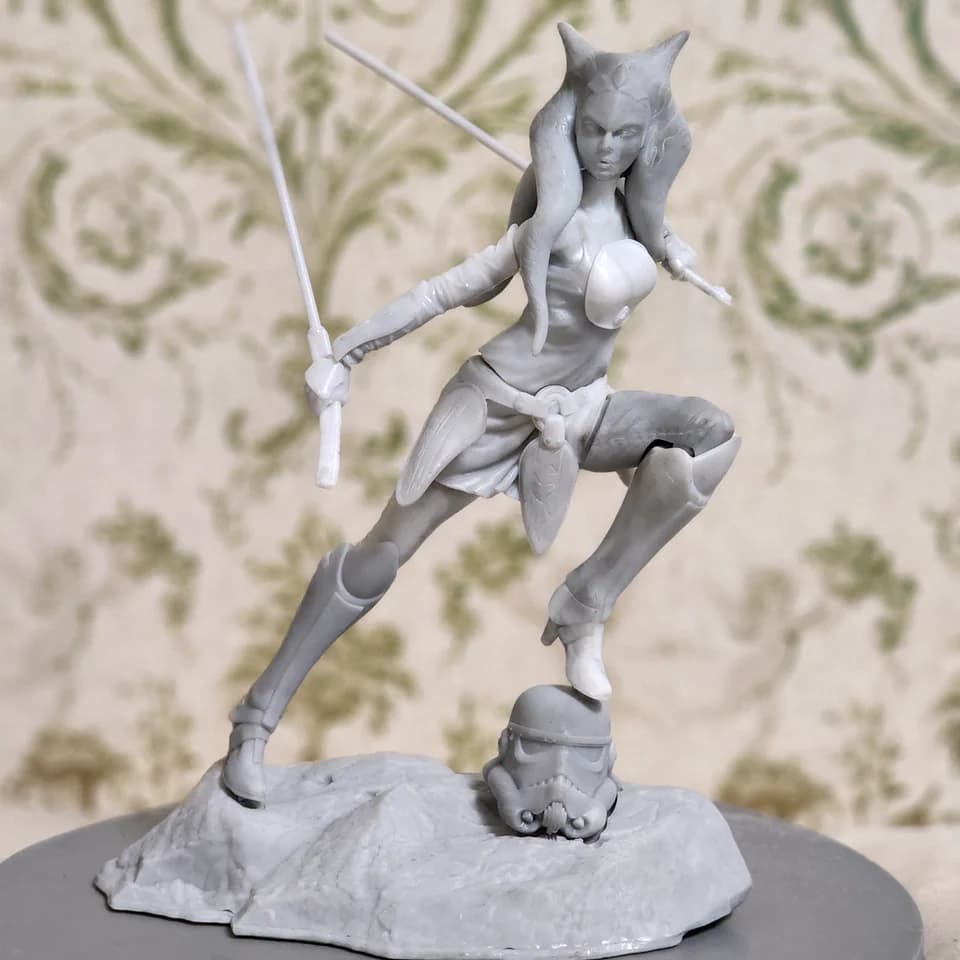 Grey Ahsoka figurine with two swords on a textured base.