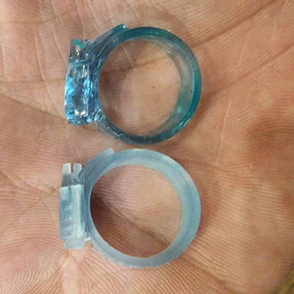 Pale and blue translucent mounting rings with side tabs resting on a palm.